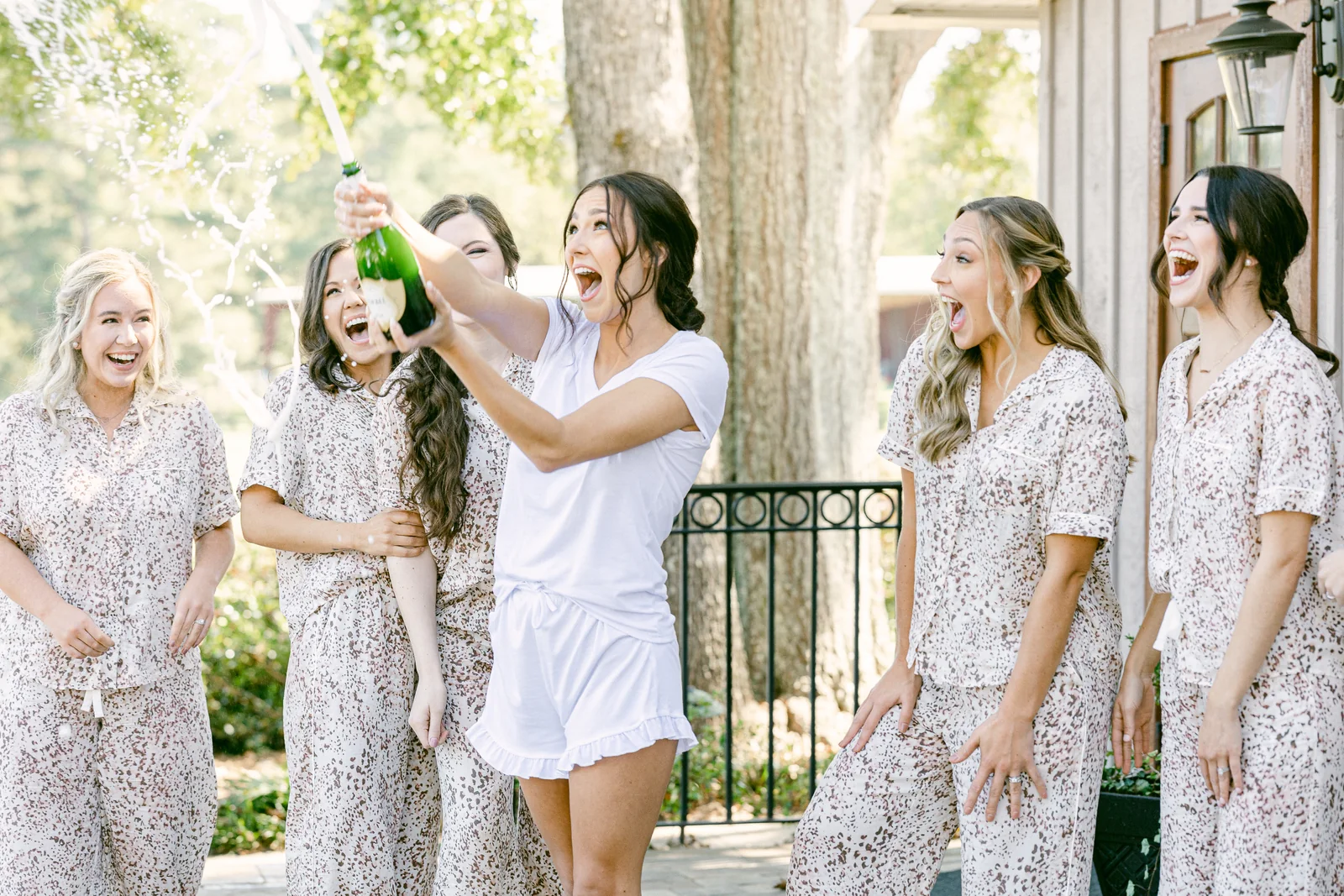 Bride celebrating with bridesmaids while getting ready