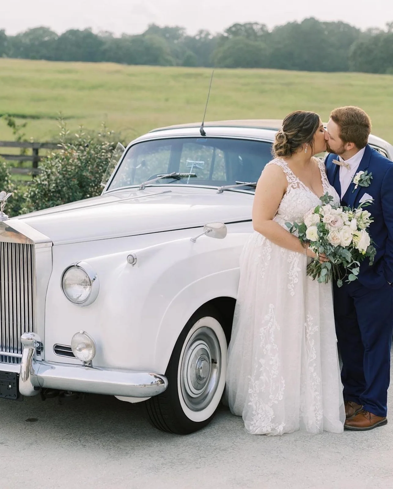 Wedding couple beside a classic car