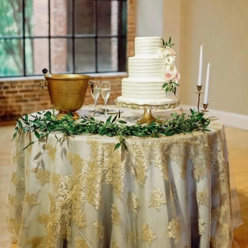 Wedding cake table styled with greenery and candles